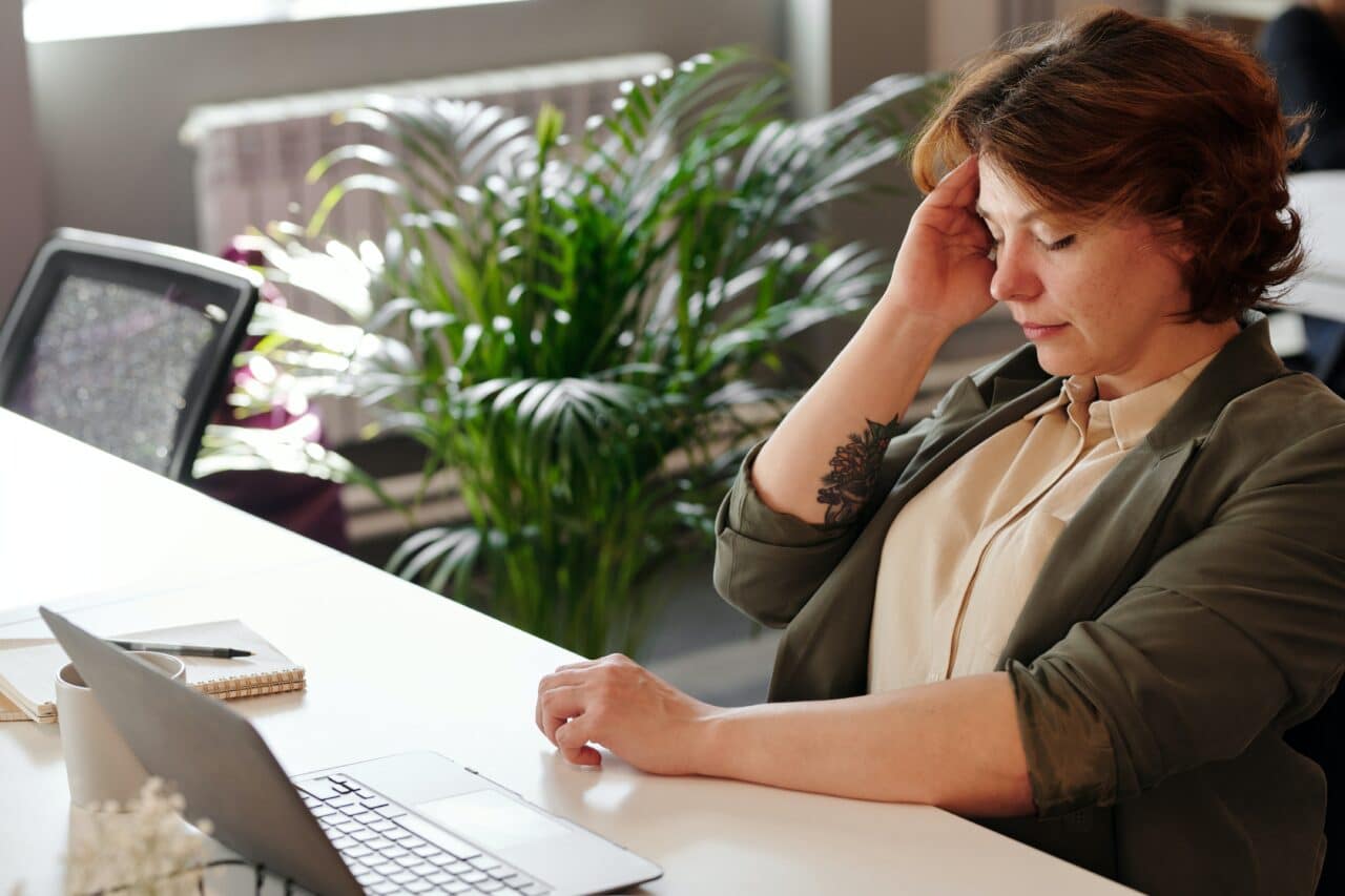 Woman suffering from a migraine at the office.