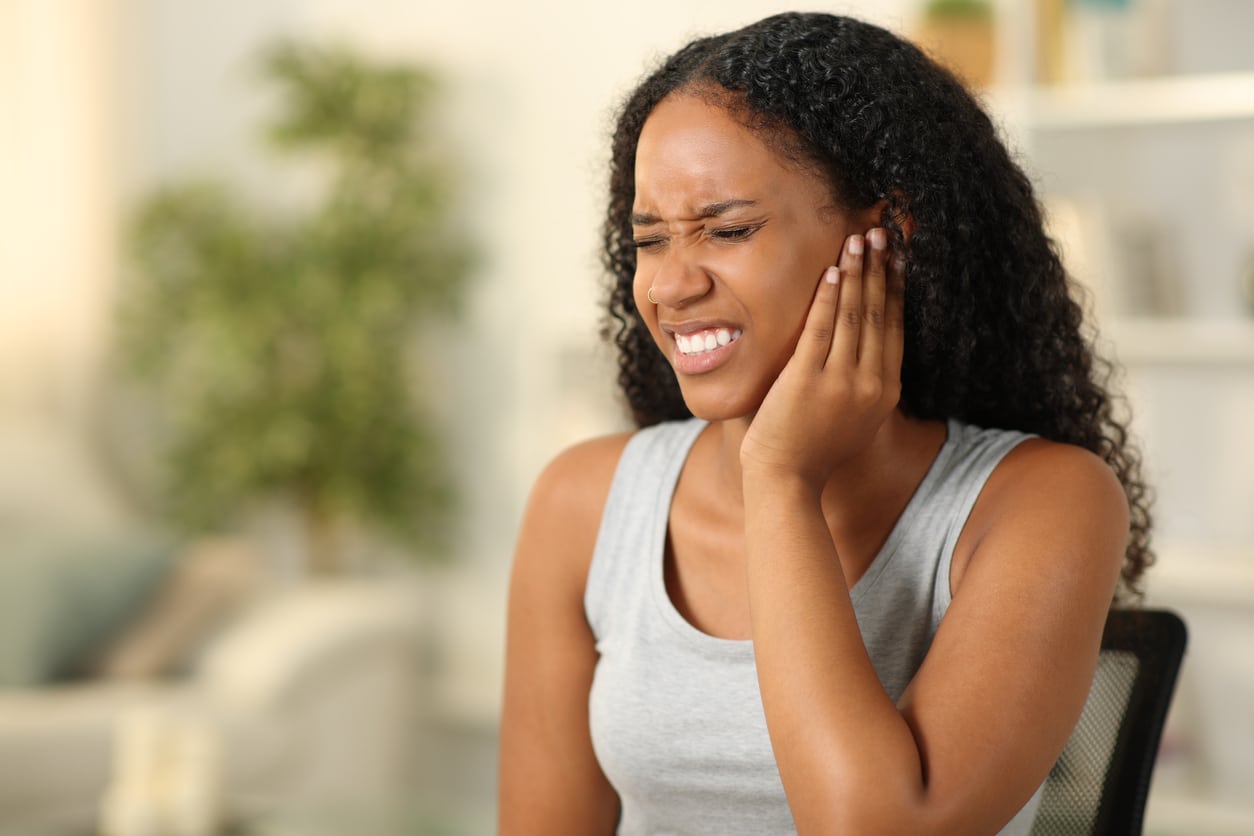 Woman with tinnitus holds ear